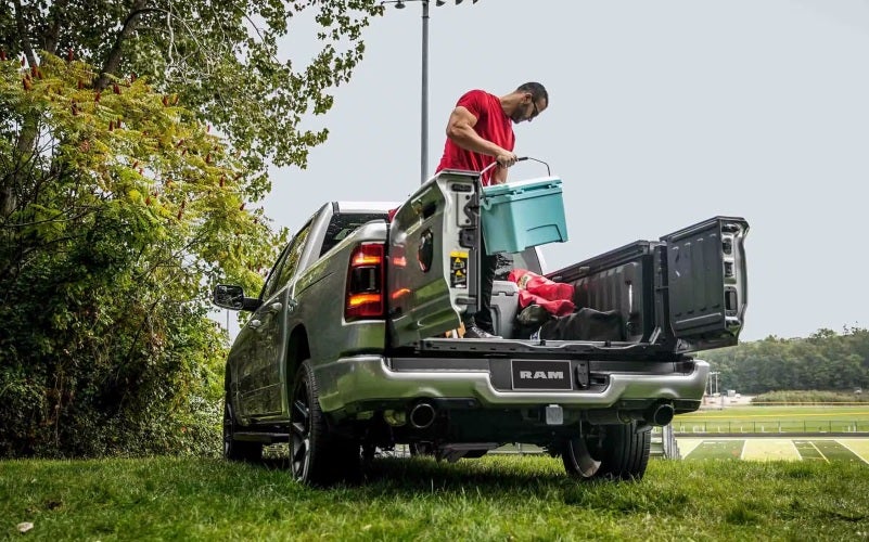 Ram Truck parked in field with man unloading cooler from truck bed